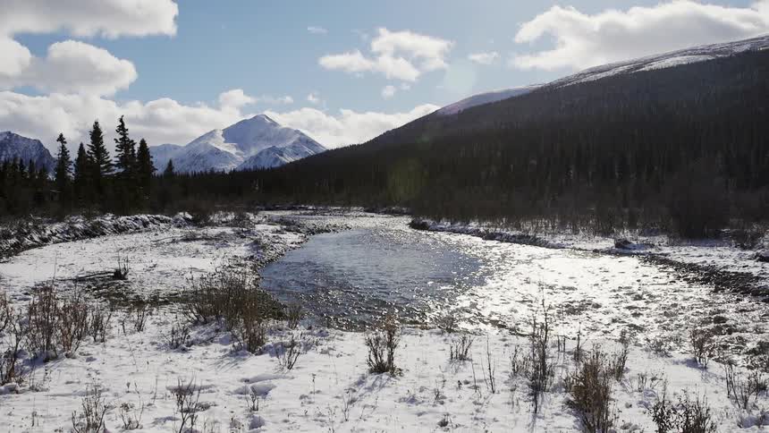A river flows through a snowy hilly landscape