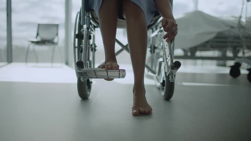 A person trying to stand from a wheelchair