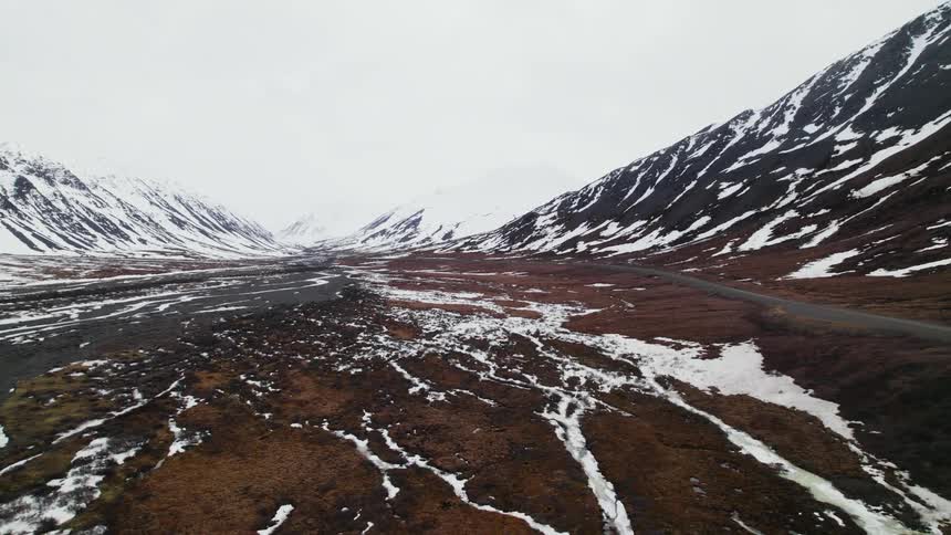 Water flows through a snowy valley