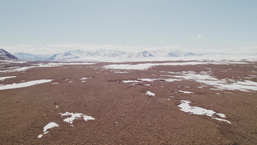 An aerial view of a snowy mountain landscape in nature