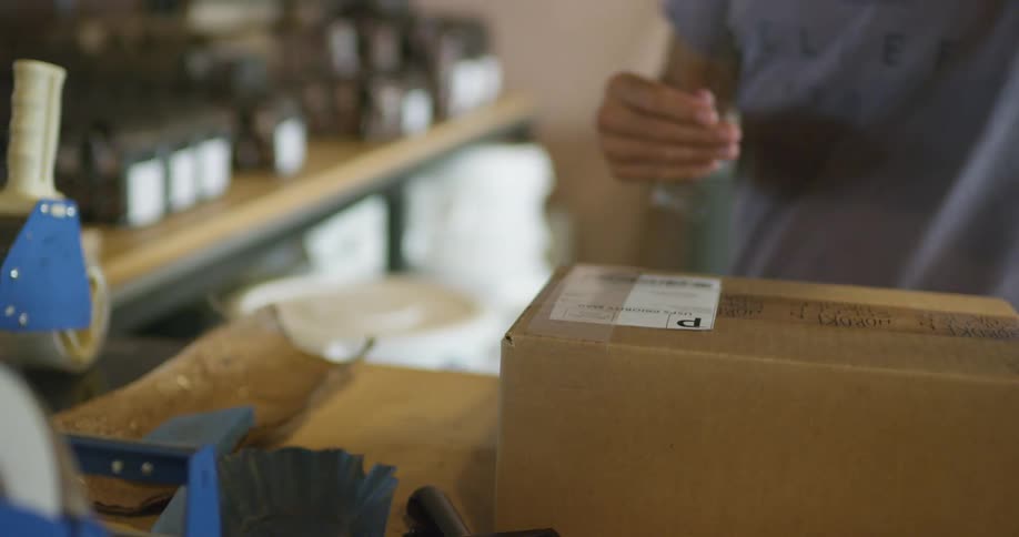 A man tapes a shipping label onto a package