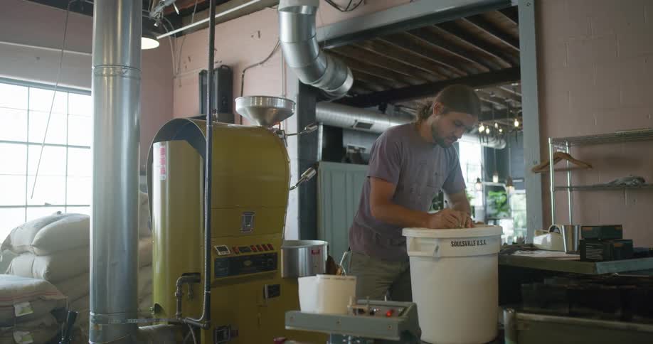 A man working in a factory marking a bucket