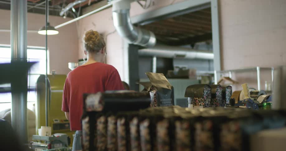 Woman working on a coffee grounds packing facility