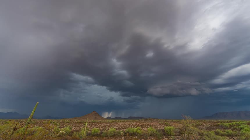 Time lapse of rain falling from the storm clouds over the plains in the desert