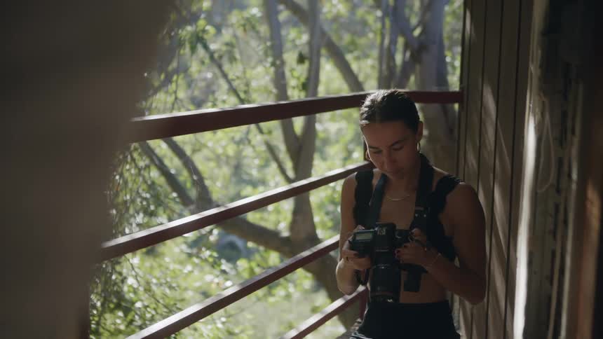 A woman using a camera outdoors in a forest area