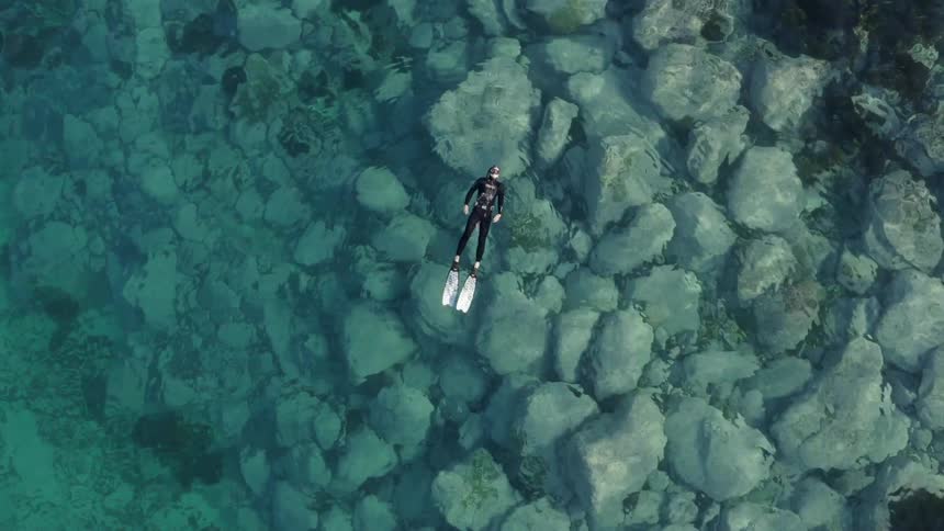 A person is floating in the clear water