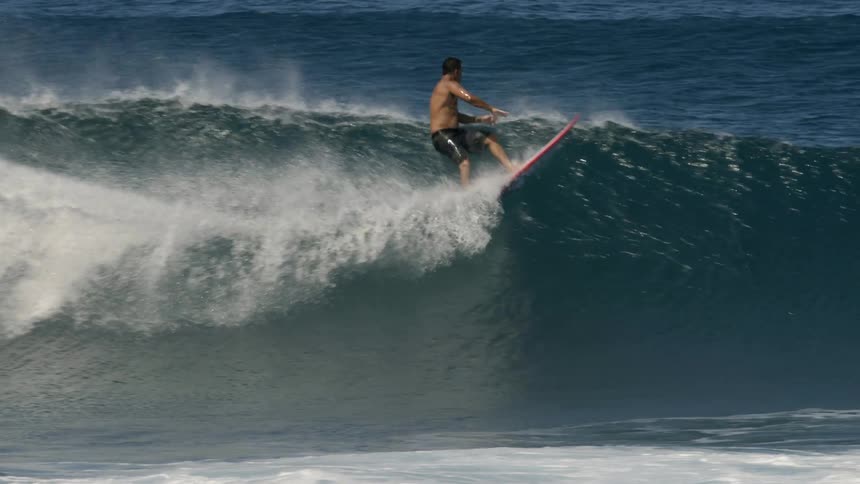 Man surfs on a big ocean wave then falls off of the surfboard