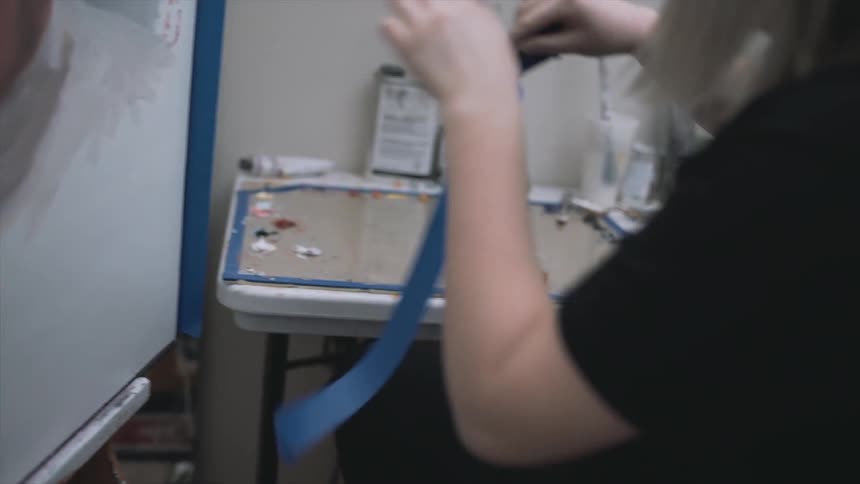 A woman is taping a portrait