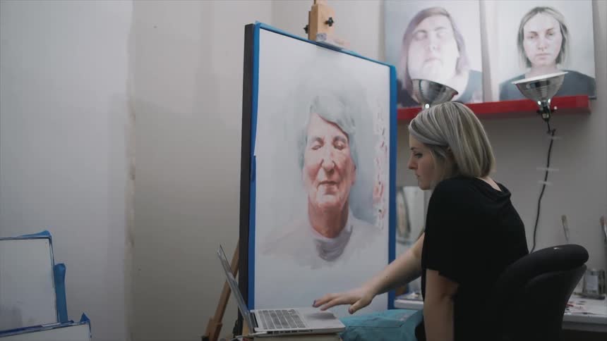 A woman is painting a portrait