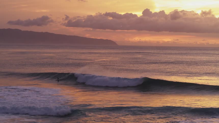 A surfer catches a perfect wave at Sunset Beach in Hawaii
