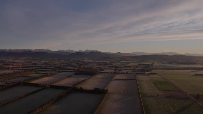 An aerial view of rural fields at sunrise