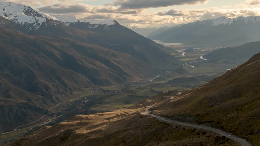 A mountain pass going along a mountain and through a valley on a cloudy day