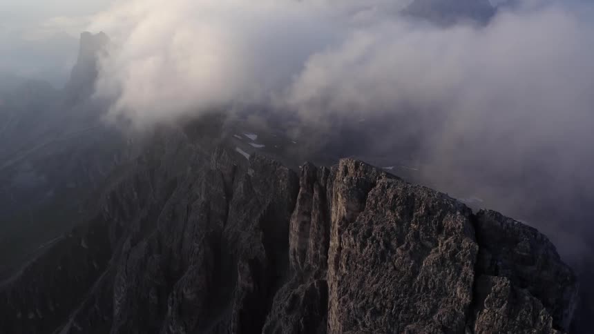 A cliff with ice and snow with clouds and the sky and the background