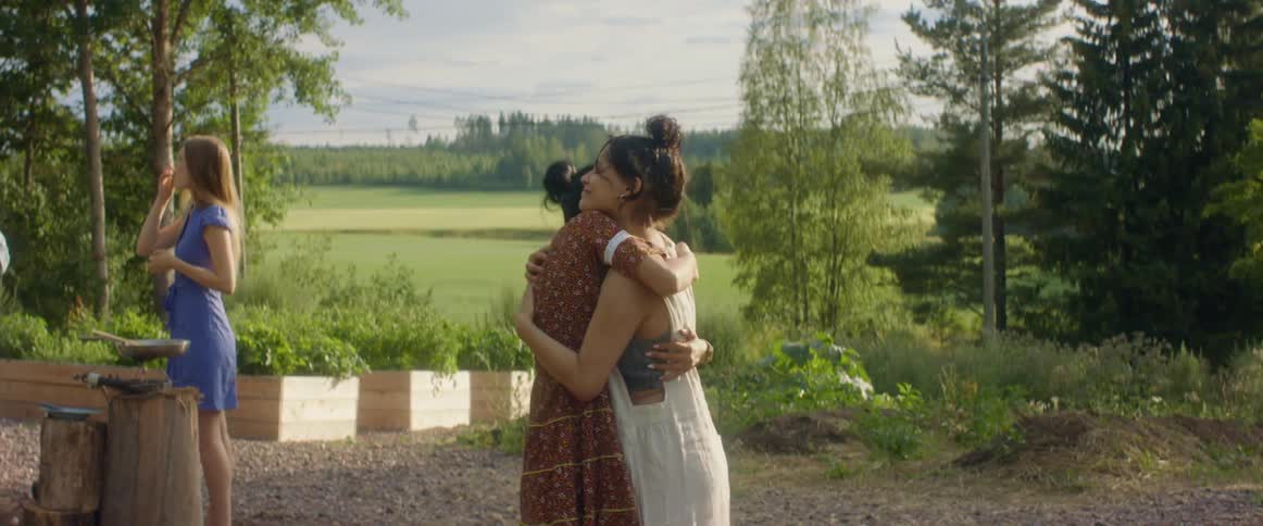 Friends greeting each other hugging in a party on the countryside