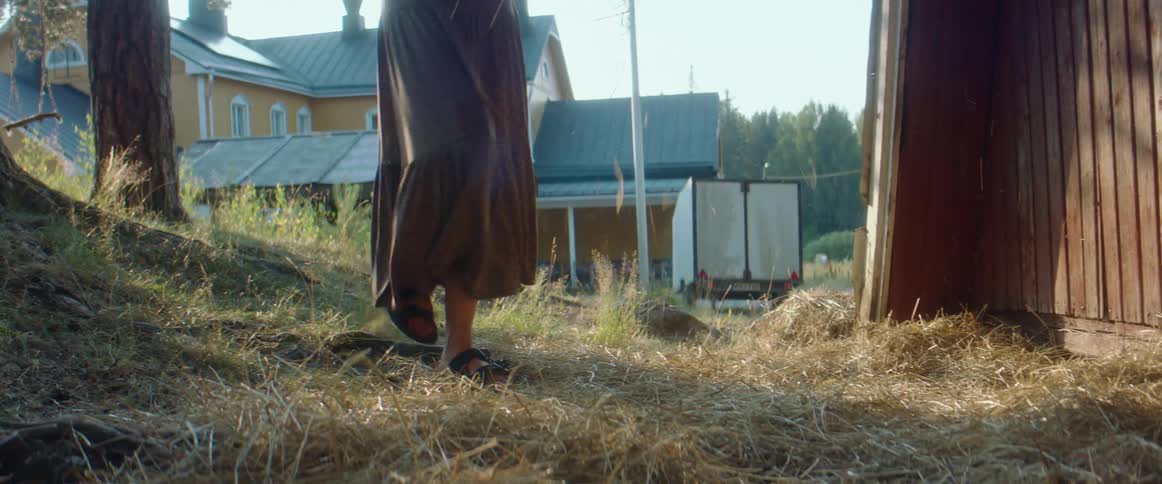 A woman spreading hay around on a farm