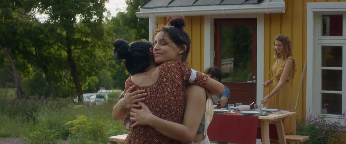 Two friends hugging each other outdoors