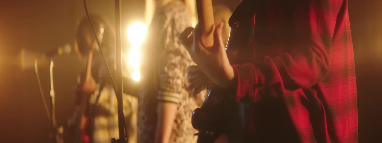 A singer spins around while performing with her female band on stage