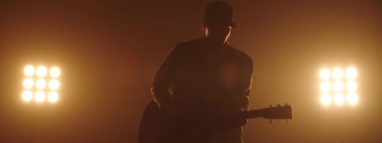 A man playing guitar on a stage
