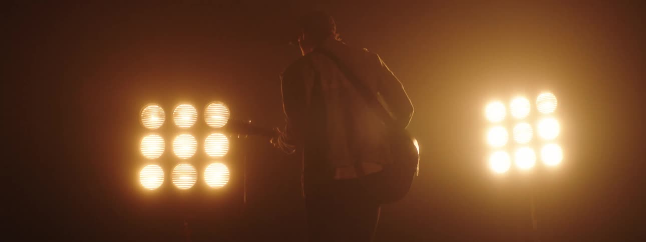 A man playing a guitar on a stage