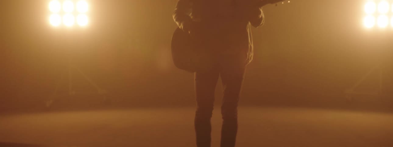 A man playing a guitar on a stage