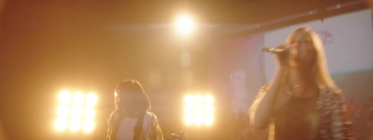 Band performs on stage backed by large digital screen