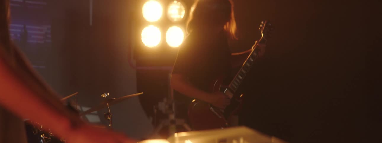 A keyboard player performs with a band on a stage