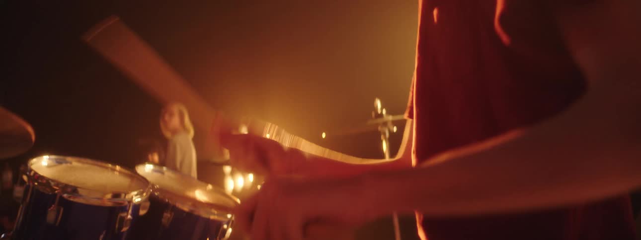 A man is playing drums on stage