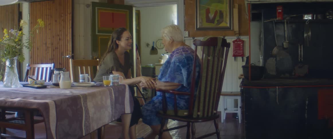 An elderly mother and her daughter sitting around talking