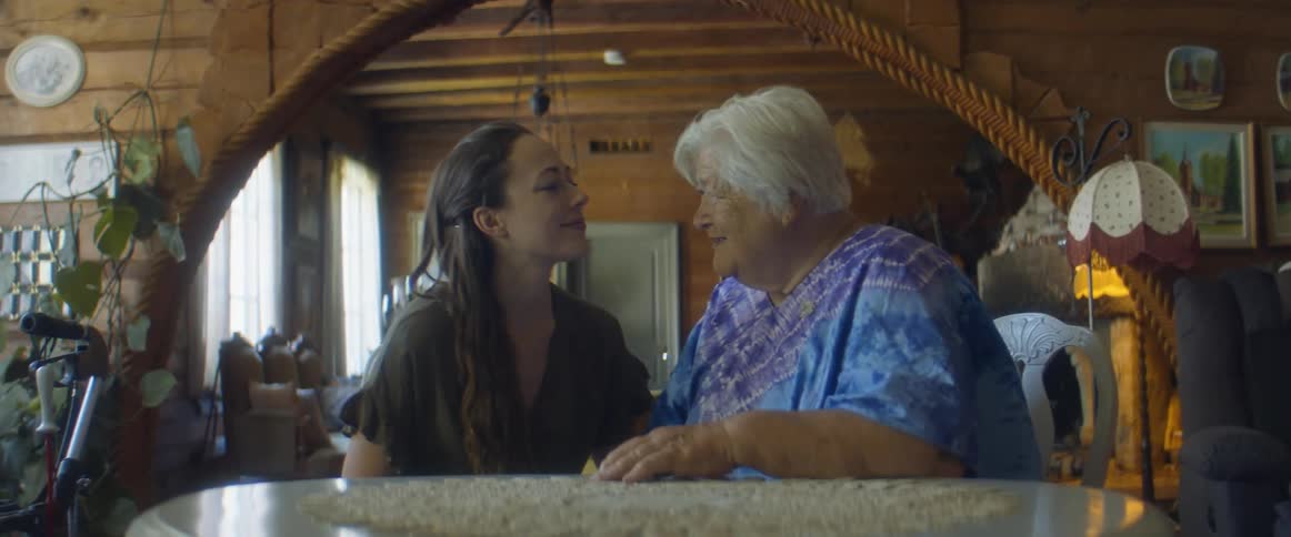 A woman hugs an older woman at the table