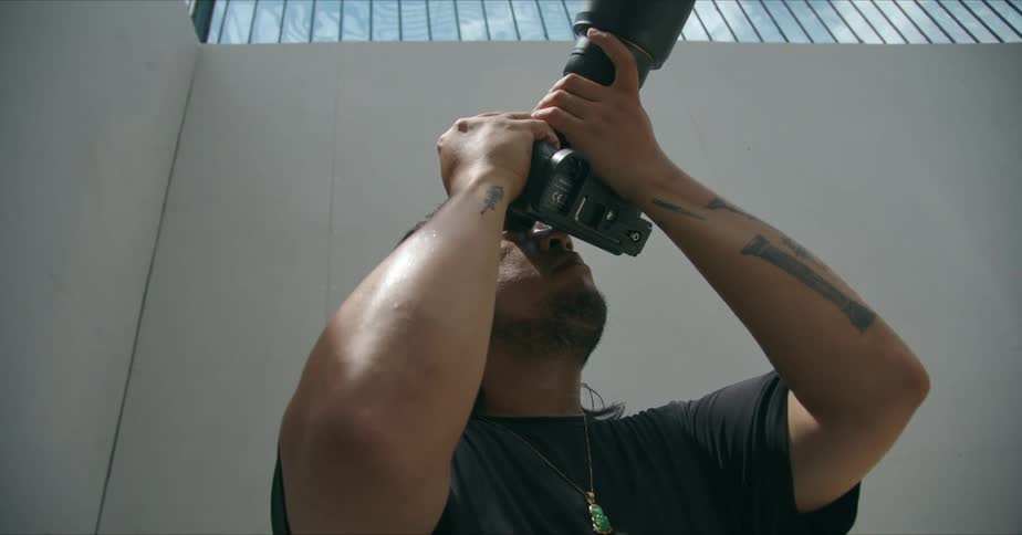 A man aims his camera toward the ceiling
