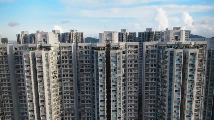 A city with high rise buildings with a lake a mountain range the sky and clouds in the background