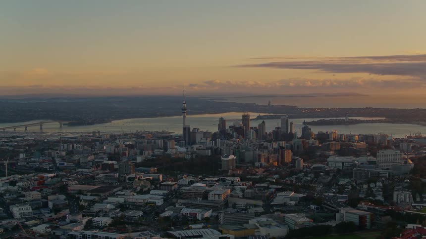 A metropolis bordered by a river at sunset