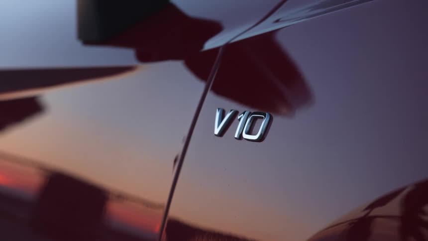 The sunset is reflected off the exterior of a red sports car