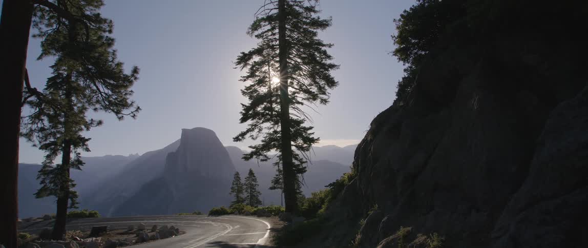 A two lane roadway winds its way through a mountainous pass
