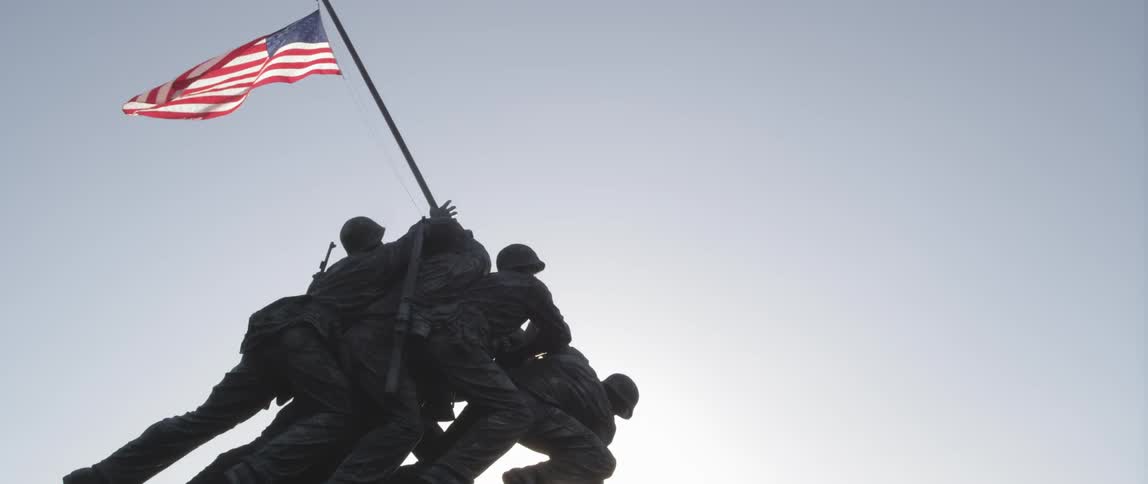 A statue of soldiers raising up a flagpole