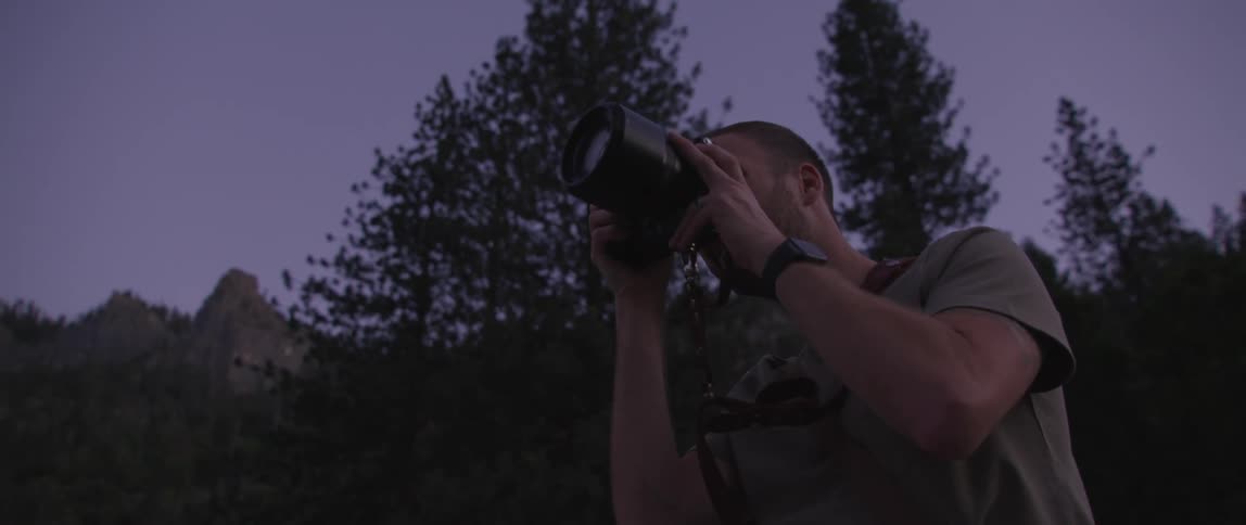 A photographer using a camera outdoors