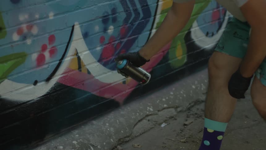 A person spray paints a wall