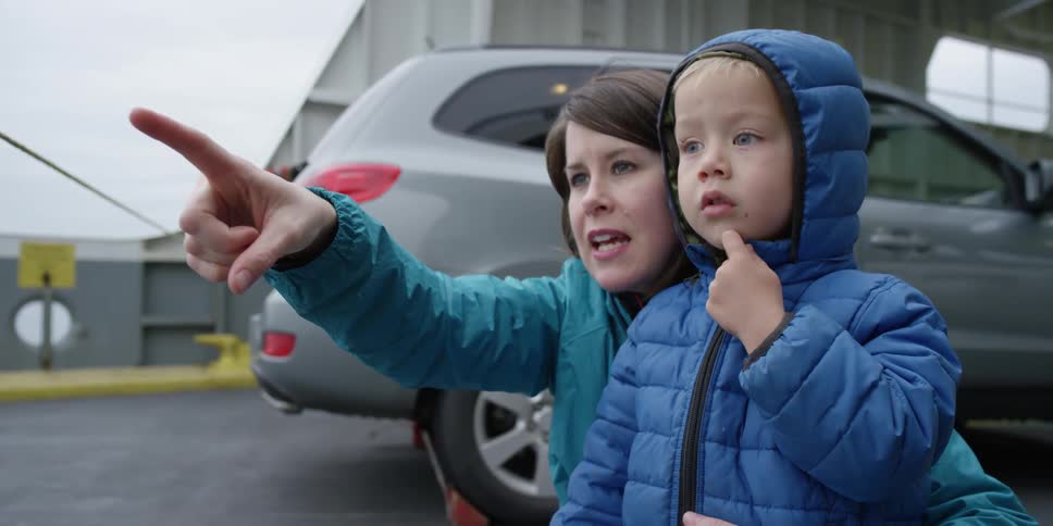 A woman points something out to a curious boy