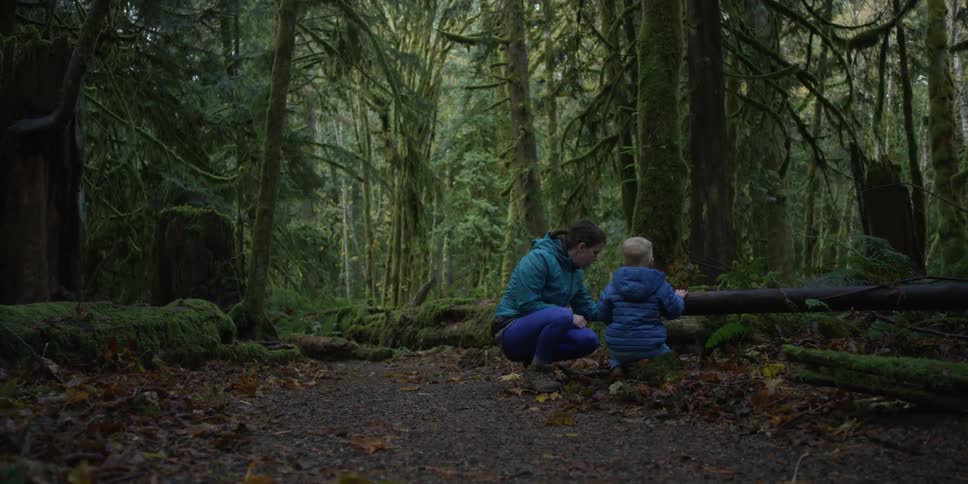 A boy and his mom in a forest