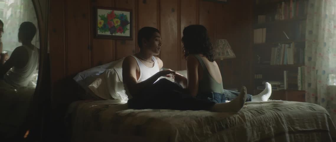 Two people sitting on a bed