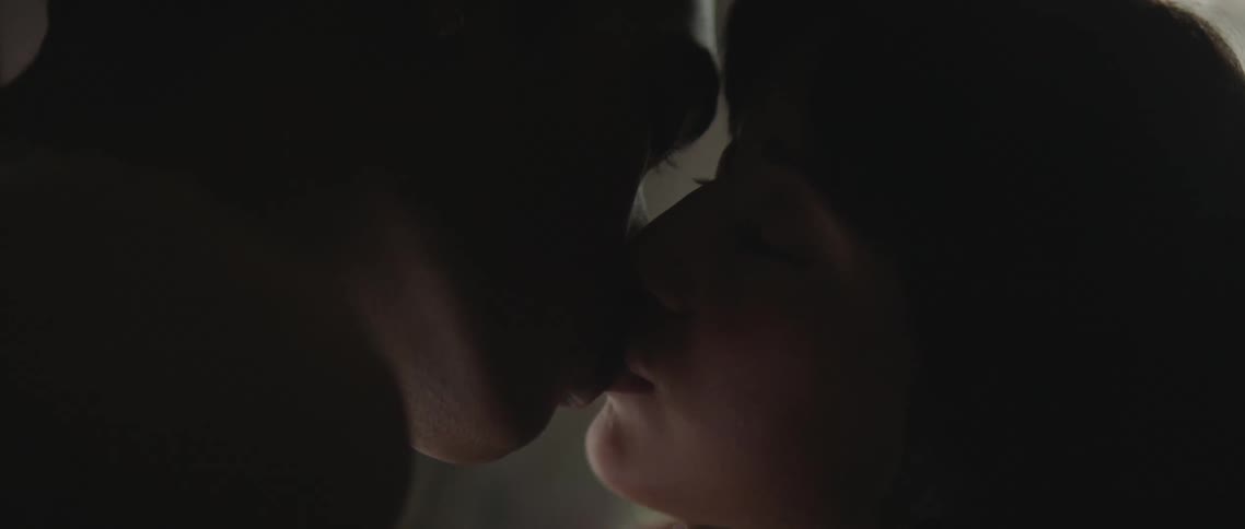 A woman leans forward and kisses her boyfriend