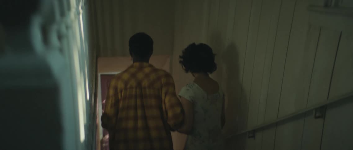 A couple run down the stairs out of the house