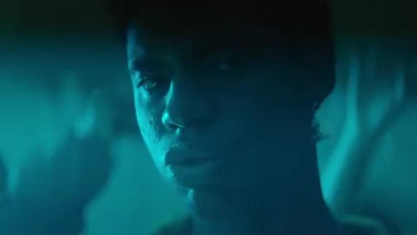 Young man looking at the camera under flashing lights inside a night club