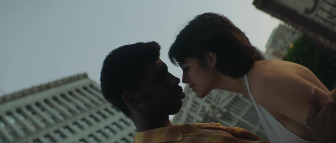 A boyfriend and girlfriend kissing outdoors