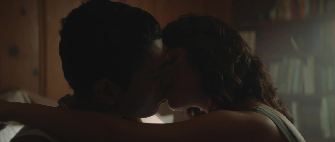 A boyfriend and girlfriend kissing in a house