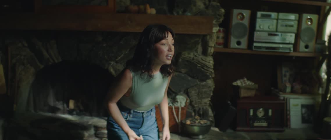 A woman yells and gestures with her hands while pacing in her living room