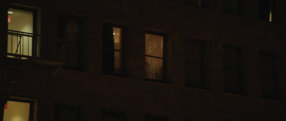 In the dark of night the many illuminated windows of an apartment building are clearly visible