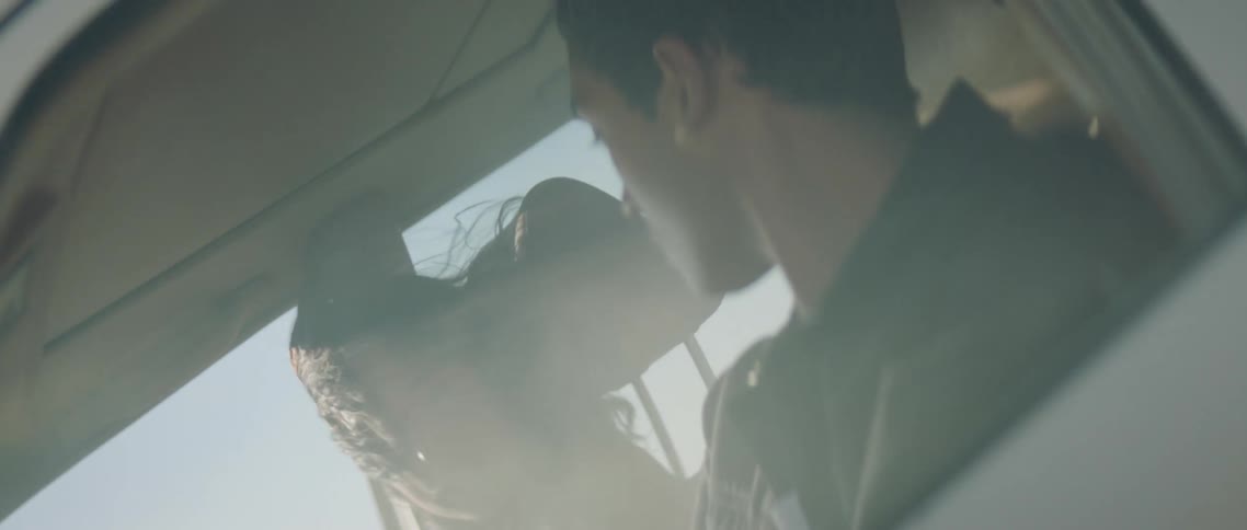 Couple look into each others eyes as fog and wind through car