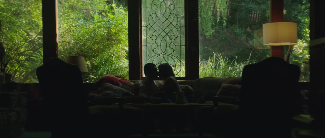 A boyfriend and girlfriend kissing on a couch