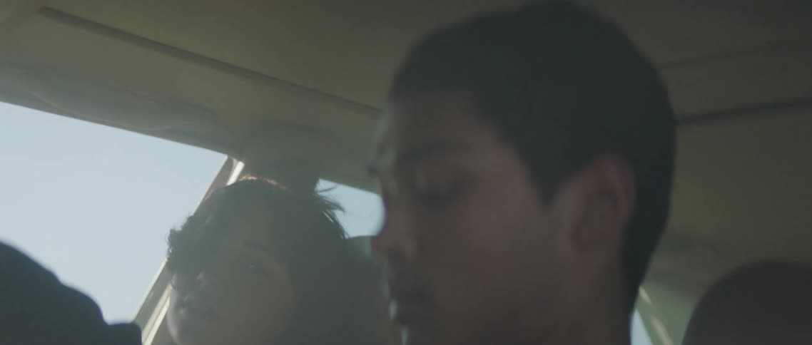 A man and a woman in a vehicle with smoke with the sky and clouds in the background